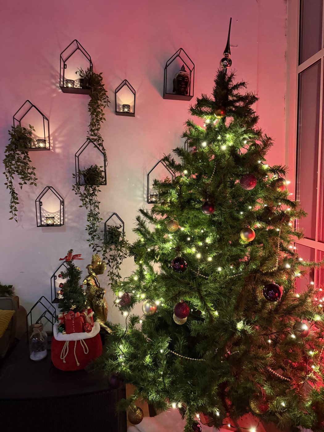 Verlichte kerstboom bij STOOM Apeldoorn, tegen de wand met zwarte lantaarnrekken en kaarslicht